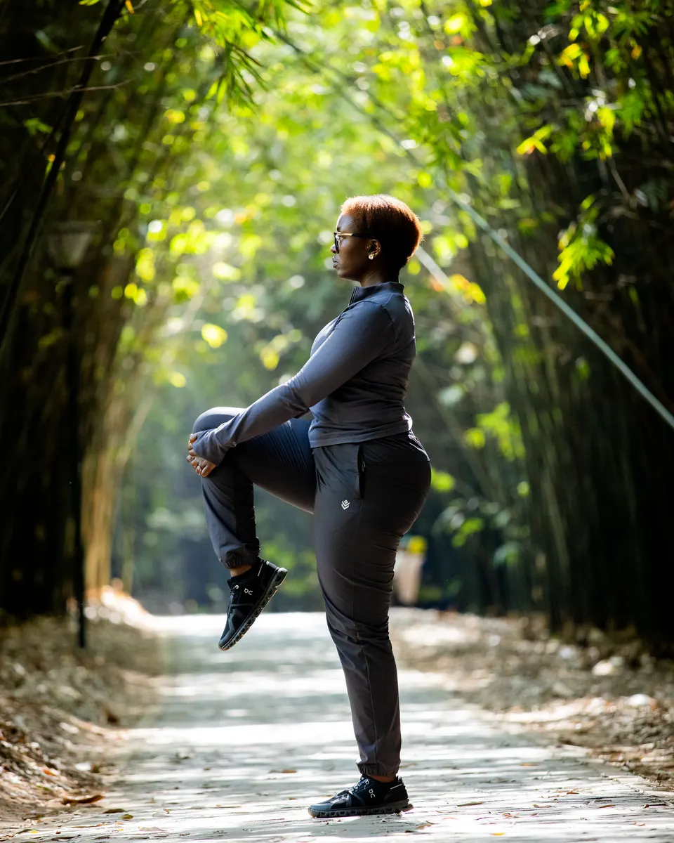 Christelle stretching on a bamboo-lined path
